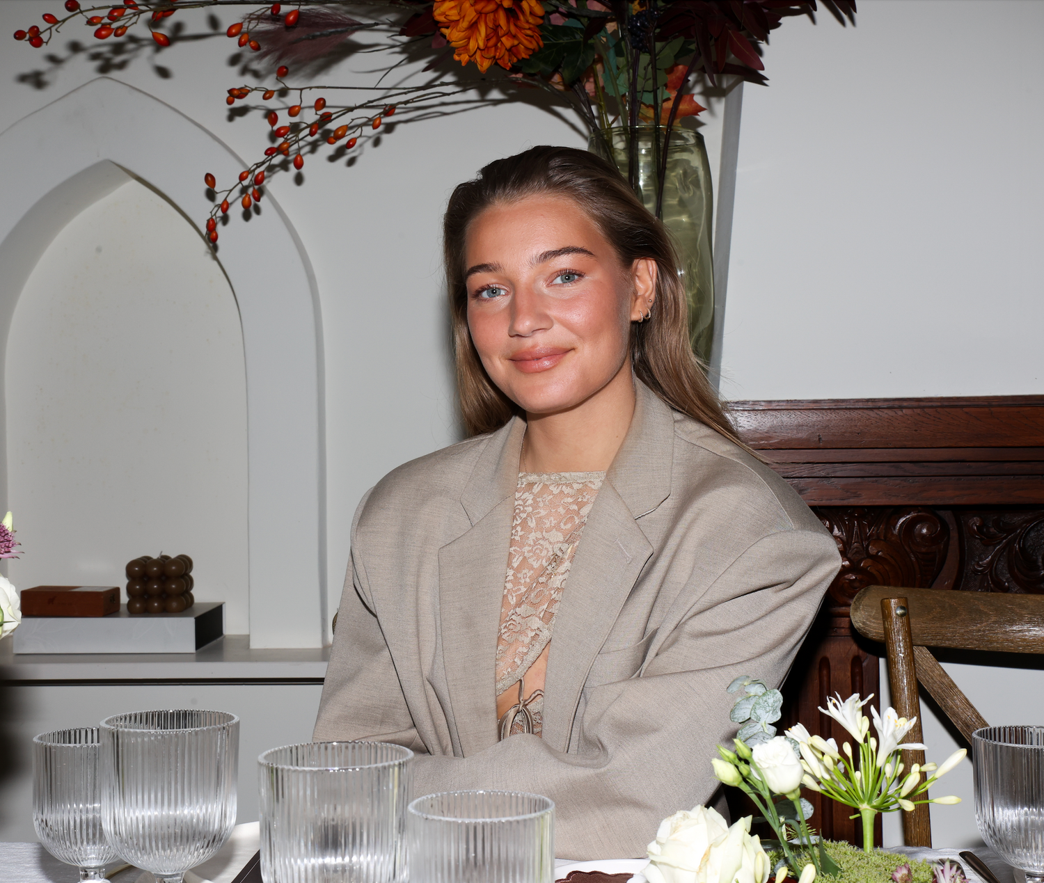 Bo Boender, co-founder of Imaginary Friends, seated at an elegant table setting with florals and warm lighting.