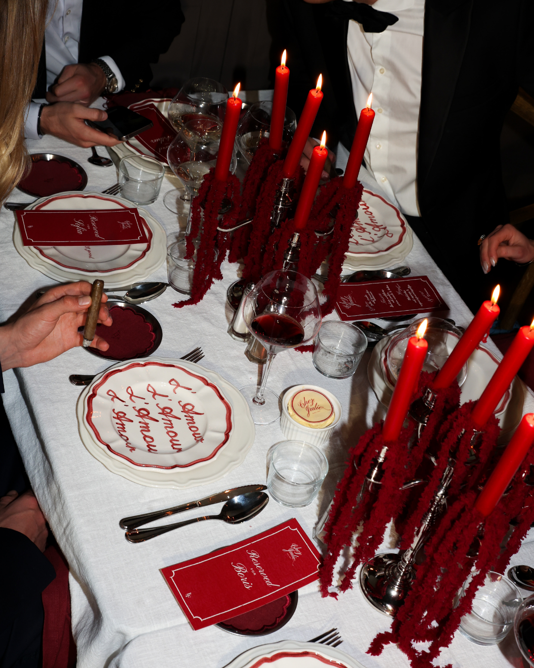 Chez Jules tablescape – red taper candles, scalloped plates, wine glasses and personalized menu cards in a romantic red theme by Imaginary Friends.