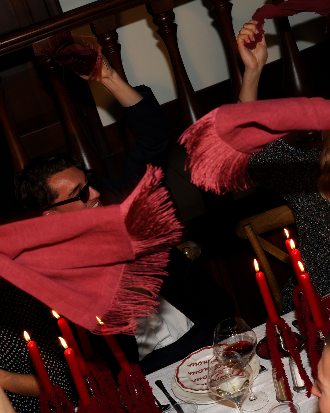 Chez Jules table styling by Imaginary Friends – red napkins in the air, red candles and wine glasses creating a lively dinner atmosphere.